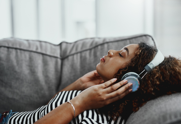 Woman lying down and listening to soothing music